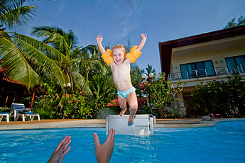 Barn som hoppar i poolen